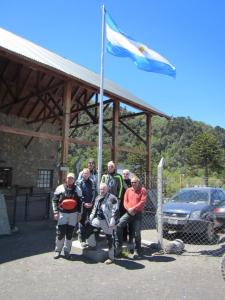 Our little group of riders, posing for a picture beneath the Argentine flag, at the border crossing.